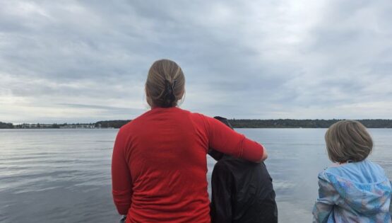 Mother and Children sitting by a lake.