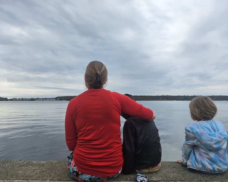 Mother and Children sitting by a lake.
