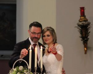 Bride and Groom lighting a candle together during wedding ceremony.