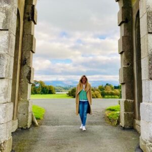 Esther walking through a big stone arch.