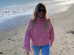 Esther smiling on a beach.