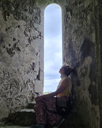 Author sitting by a window inside Knockmoy Abbey, Co. Galway, Ireland.