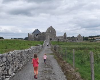 Family walking towards Knockmoy Abbey, Co. Galway, Ireland.